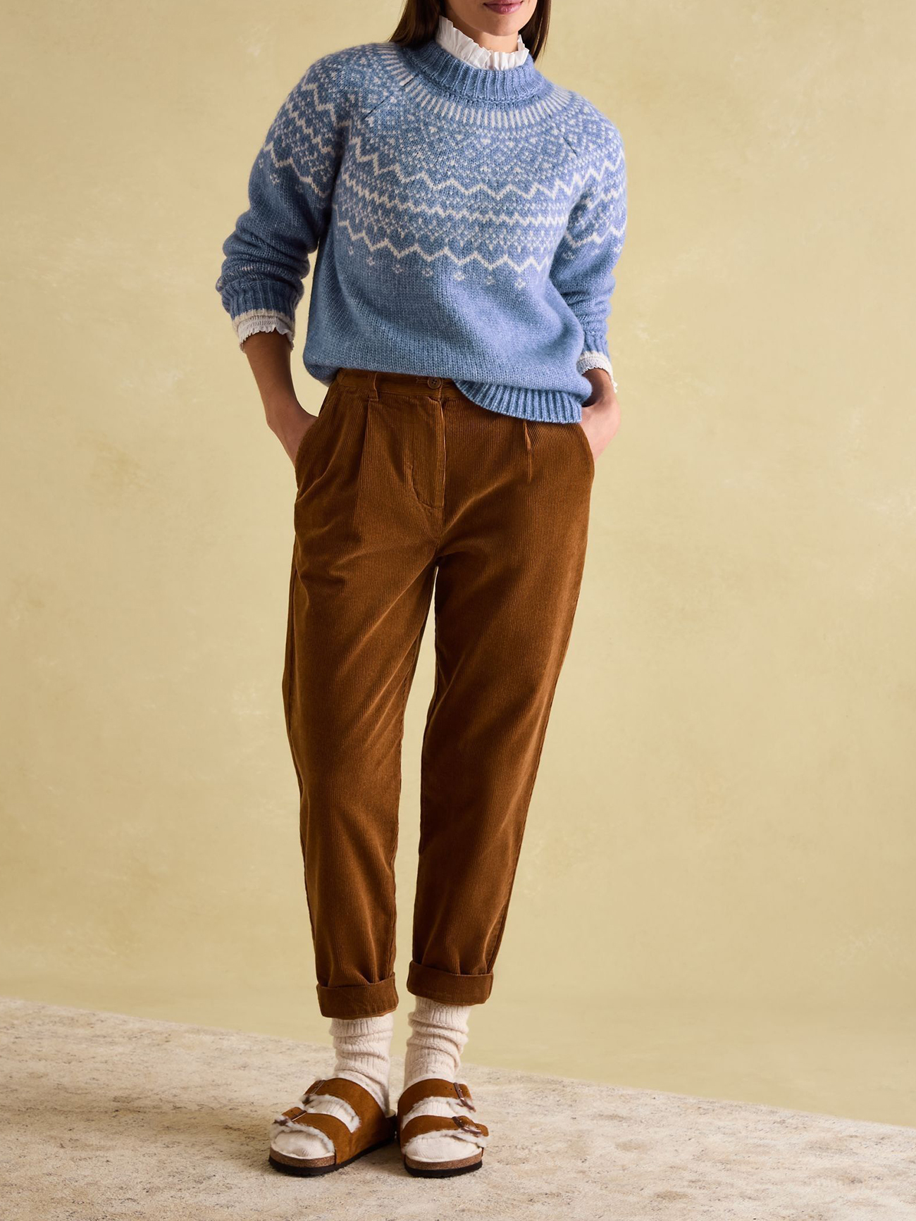 Woman in a Fair Isle sweater and corduroy pants