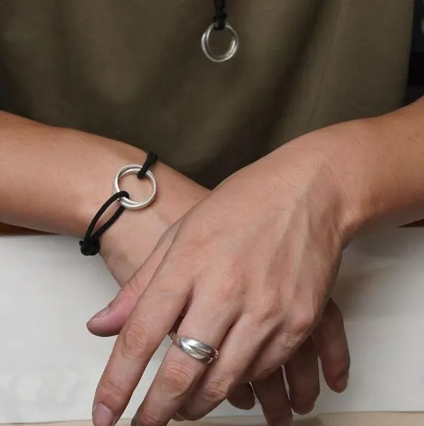 Not every ring needs to shine to stand out.  The imperfect texture, intertwined silhouette and subtle red detailing give this silver ring a worn-in, vintage character that feels different from ordinary jewelry.  For denim. For black tees. For streetwear.