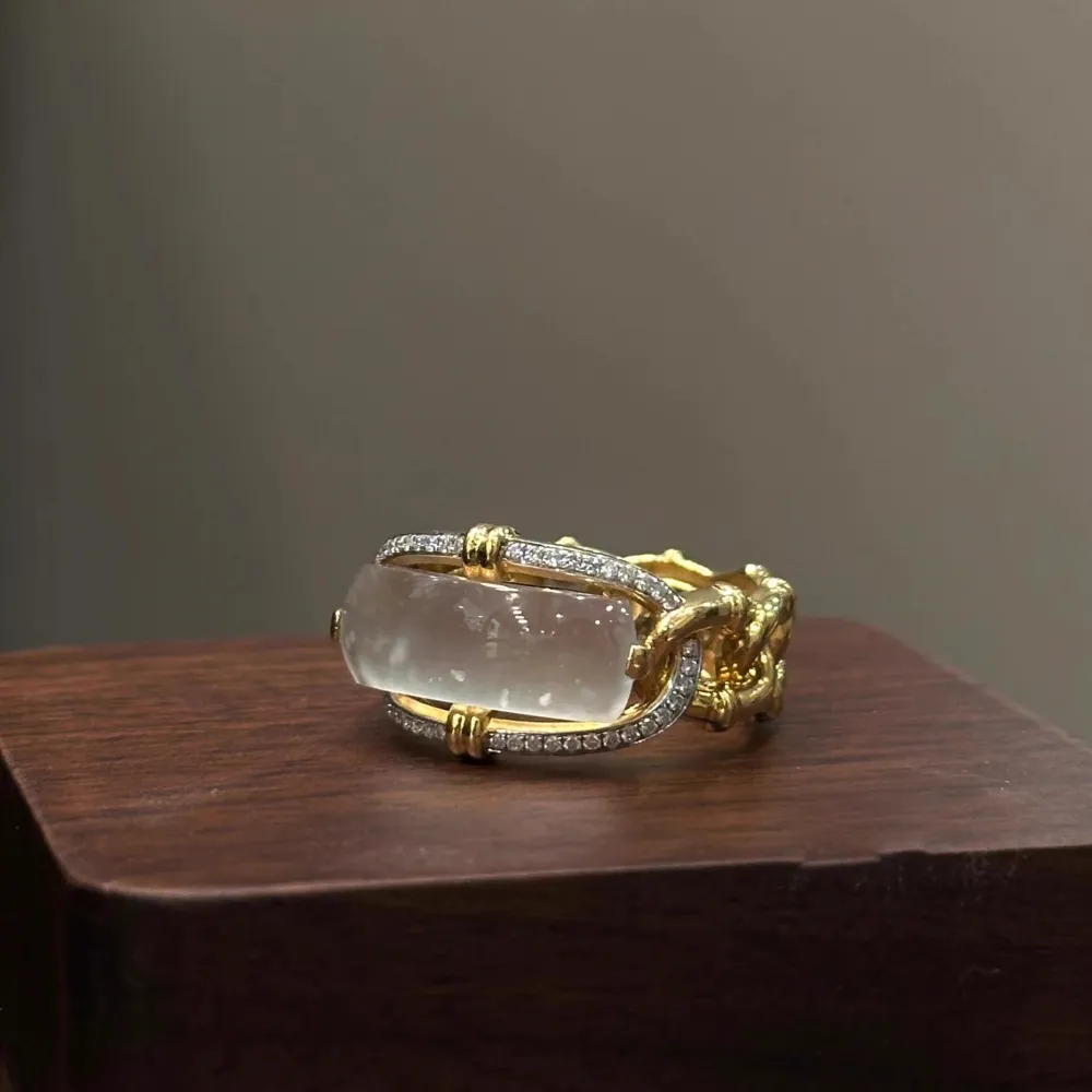 ✨ A ring that instantly elevates your look. Featuring a luminous translucent center stone, gold-tone detailing, and sparkling accents, this statement ring brings effortless elegance to every outfit.
